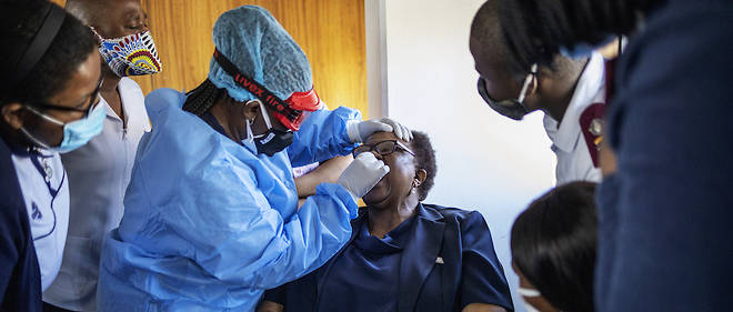 L'infirmiere de Medecins sans frontieres (MSF), Bhelekazi Mdlalose (3e L), 51 ans, illustre comment effectuer un test sur ecouvillon sur une infirmiere participant a un cours de formation sur le coronavirus a Johannesburg.
