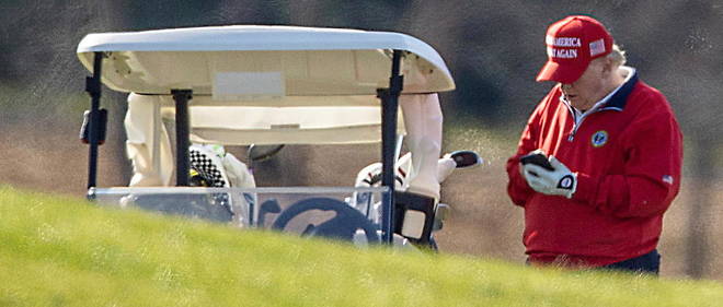 Le president americain Donald Trump consulte son telephone en jouant au golf le 26 novembre 2020.
