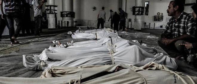 Des corps sans vie d'adultes et d'enfants ont ete enveloppes dans des linceuls apres l'attaque chimique au gaz sarin qui a vise la Ghouta orientale, le 21 aout 2013, et qui a fait 1 400 morts.
