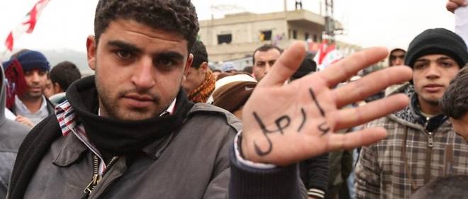 Un manifestant montre le mot << Irhal >> (Quitter) lors de la manifestation du vendredi a Wadi Khaled (frontiere libano-syrienne) contre le regime du president Bashar el-Assad le 30 decembre 2011.
