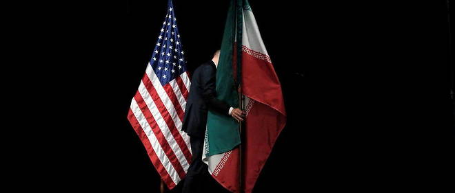 An official hoists Iranian and American flags on stage after the conclusion of the Iranian nuclear deal on July 14, 2015 in Vienna, Austria.