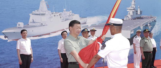 Le president chinois Xi Jinping baptise le sous-marin nucleaire << Changzheng-18 >> et presente le drapeau de l'armee populaire de liberation au capitaine et au commissaire politique du navire.
