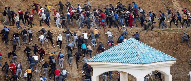 Des migrants fuient la police marocaine pres de Ceuta le 18 mai 2021.
