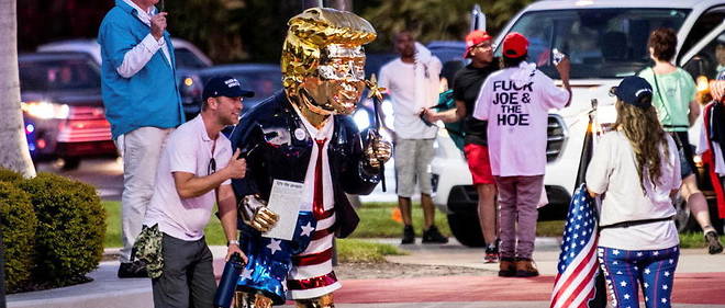 Un supporteur de Donald Trump pose devant une statue de l'ancien president a Orlando, en Floride, le 28 fevrier 2021.
