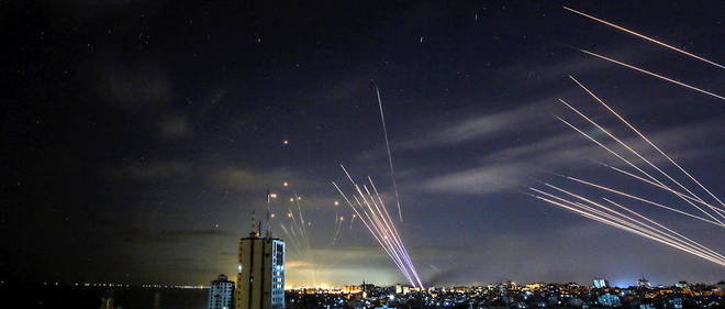 Le systeme de defense israelien, le Dome de fer (a gauche), intercepte des roquettes (a droite) tirees par le Hamas en direction de la ville de Beit Lahia, le 16 mai 2021. 
