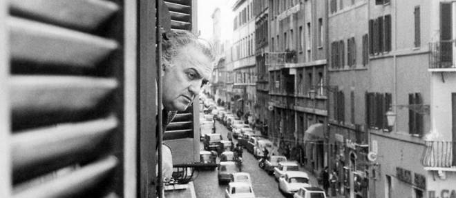 Federico Fellini a la fenetre de son bureau de la via Sistina, en 1974.
