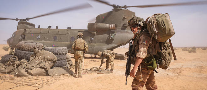 Un soldat francais devant un helicoptere Chinook britannique, au Burkina Faso, en avril 2021.
