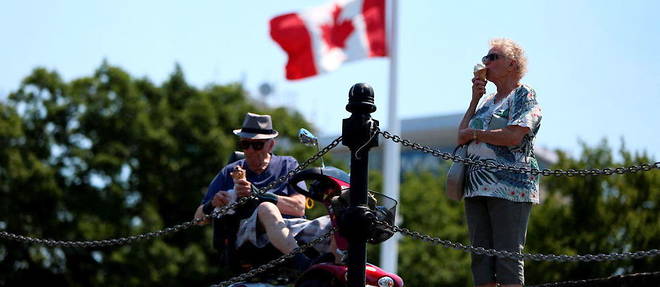 Un couple de Canadiens mangeant une glace a Victoria, alors qu'une vague de chaleur frappait l'ouest du pays fin juin.
