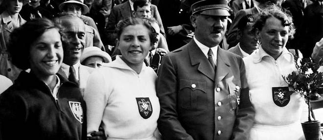De gauche a droite : la Polonaise medaillee de bronze au javelot Maria Kwasniewska, la medaillee d'argent allemande de javelot Luise Kruger et l'Allemande medaillee d'or Ottilie Tilly Fleischer a cote d'Adolf Hitler.
