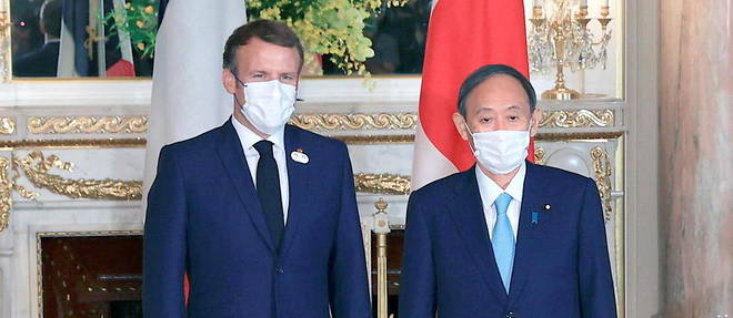 Le president francais Emmanuel Macron au cote du Premier ministre japonais Yoshihide Suga, le 24 juillet 2021 a Tokyo.
