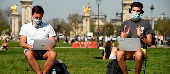 Deux hommes teletravaillent a Paris.
