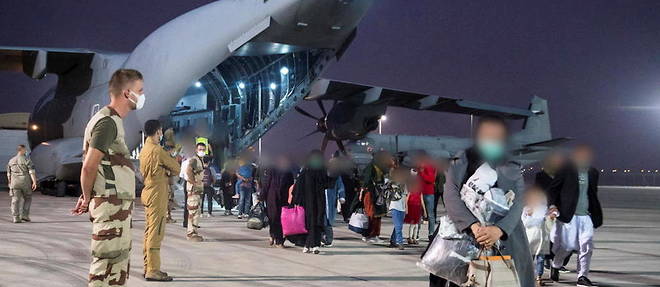 Des refugies afghans debarquent d'un avion militaire francais a Abu Dhabi le 18 aout 2021.

