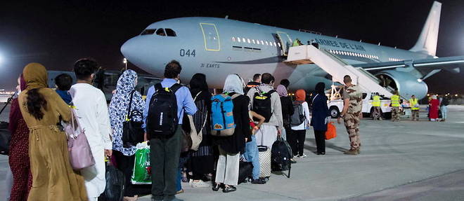Refugies afghans attendant de monter a bord d'un avion de transport militaire francais A330 a la base aerienne Al Dhafra, pres d'Abu Dhabi. Ils sont evacues en France dans le cadre de l'operation Apagan, lancee le 15 aout, apres la prise du pouvoir par les talibans en Afghanistan.
