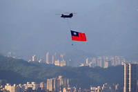 Un helicoptere militaire fait flotter un drapeau de Taiwan dans le ciel de Taipei le 5 octobre 2021.
