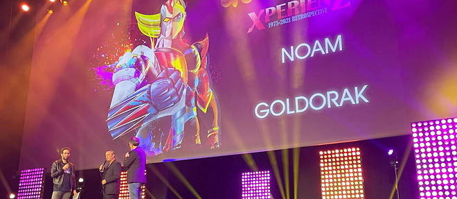 Entoure d'Emmanuel Levy (NRJ) et Florian Gazan (RTL), Noam, second chanteur du generique francais de << Goldorak >>, repond a quelques questions sur la scene  du Grand Rex avant d'entamer le tube << Goldorak le grand >> devant 2 700 fans ivres de nostalgie.
