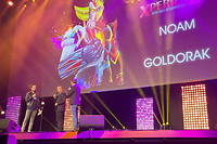 Entouré d'Emmanuel Levy (NRJ) et Florian Gazan (RTL), Noam, second chanteur du générique français de « Goldorak », répond à quelques questions sur la scène  du Grand Rex avant d'entamer le tube « Goldorak le grand » devant 2 700 fans ivres de nostalgie.
