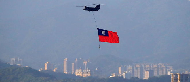 Un helicoptere porte le drapeau de Taiwan au-dessus de Taipei.
