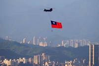 Un hélicoptère porte le drapeau de Taïwan au-dessus de Taipei.
