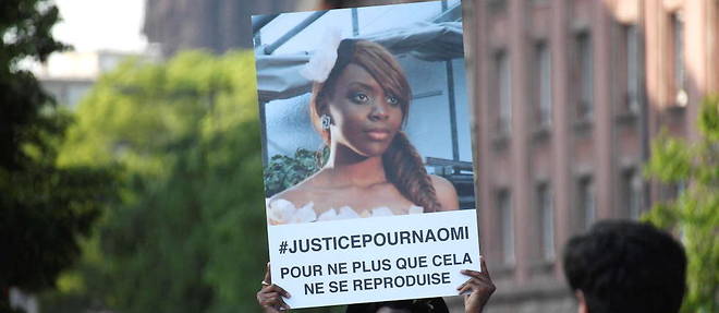 Le frere de Naomi Musenga, Gloire Musenga, brandissant le portrait de sa soeur, lors d'une marche silencieuse en son honneur en mai 2018.
