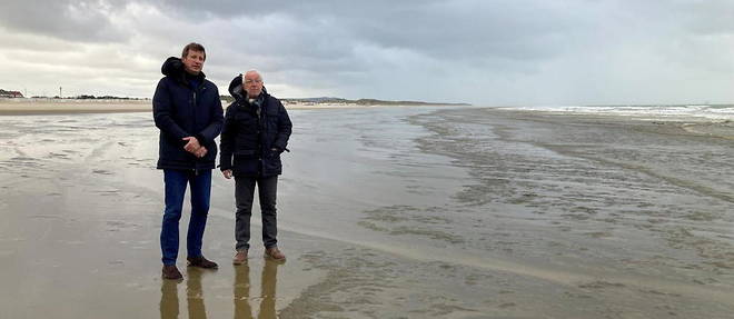 Yannick Jadot (a gauche) se recueille sur la plage de Calais avec le president d'une association d'aide aux migrants.

