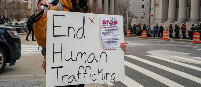 Des manifestants se rassemblent pour protester contre la traite des etres humains au palais de justice ou le proces de Ghislaine Maxwell se tient, a New York.
