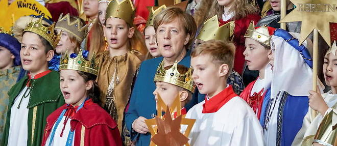 La chanceliere allemande Angela Merkel chante entouree d'enfants, en janvier 2019.

