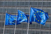 Drapeaux européens flottant dans le vent près du bâtiment de la Commission européenne.
