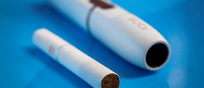 Le dispositif electronique IQOS de Philip Morris a cote d'une cigarette classique.
