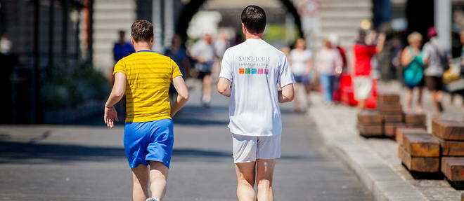 Deux hommes en train de courir, en plein soleil, sur les berges de la Seine a Paris.

