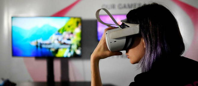 Une jeune femme portant un casque de realite virtuelle, l'une des portes d'entree pour les mondes virtuels.
