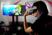 Une jeune femme portant un casque de réalité virtuelle, l'une des portes d'entrée pour les mondes virtuels.
