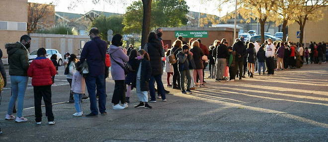 Des Espagnols font la queue pour faire vacciner leurs enfants. 
