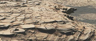 Cette vue du cratère Gale a été reconstituée à partir d'images prises par la Mast Cam du rover « Curiosity » au 2 729 e  jour martien (sol) de sa mission. Il montre la formation de grès baptisée Stimson où « Curiosity » a recueilli l'un des échantillons enrichi en carbone 12.
