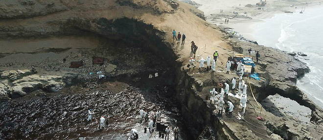 Les autorites sanitaires nettoient les cotes peruviennes envahies par la maree noire, a Lima, le 22 janvier 2022.
