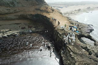 Les autorités sanitaires nettoient les côtes péruviennes, envahies par la marée noire, à Lima, le 22 janvier 2022.
