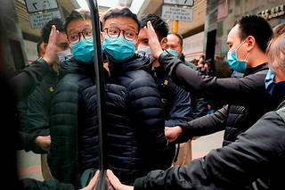  Le rédacteur en chef du site d’information Stand News, Patrick Lam, est arrêté par la police pour « publication séditieuse », le 29 décembre 2021, à Hongkong.   ©Vincent Yu/AP/SIPA