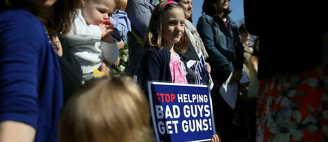 Une jeune manifestante anti-armes, brandissant une pancarte << Arretez de donner des armes aux mechants >> a Washington, en avril 2016 (photo d'illustration).
