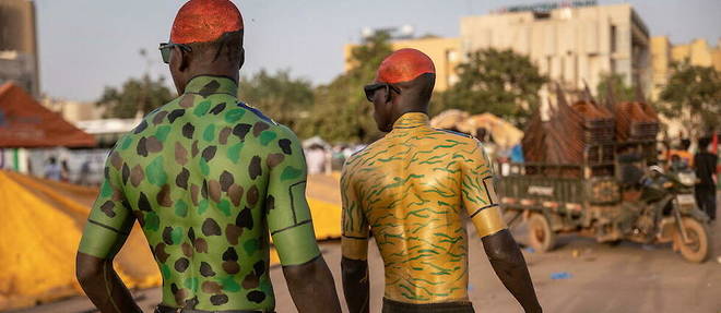 Pendant que des supporters des nouvelles autorites se peignent le corps aux couleurs du Burkina, une commission propose un delai de trente mois avant un retour a l'ordre constitutionnel. 
