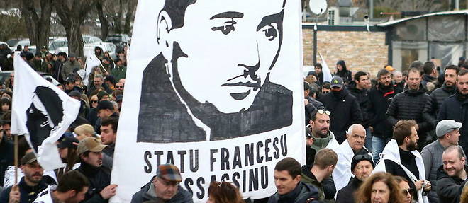 Des milliers de personnes se sont rassemblees dans la rue ce dimanche a Corte pour defiler derriere une banderole au slogan guerrier et accusateur porte par de jeunes nationalistes : << Statu francese assassinu ! >> (<< Etat francais assassin >>).
