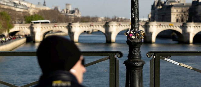 Un homme profitant du soleil sur le pont des Arts a Paris.
