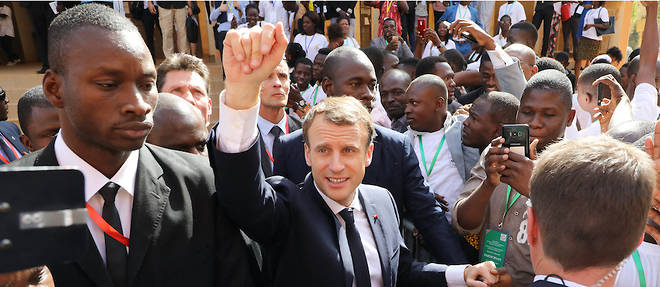 Emmanuel Macron entoure de jeunes Burkinabes apres son discours et un vif echange avec les etudiants a l'universite de Ouagadougou.
