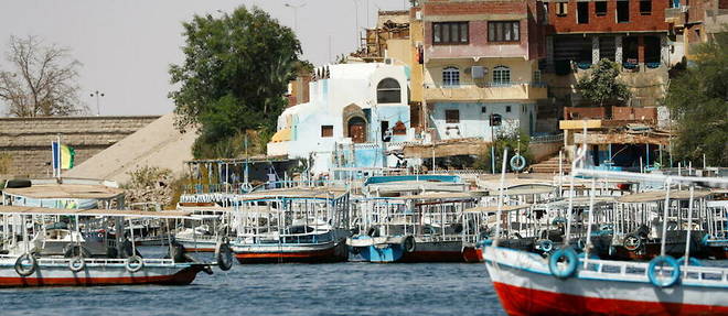Des bateaux et des maisons pres du reservoir du barrage d'Assouan, en Haute-Egypte, a environ 920 km au sud du Caire, la capitale. (illustration)
