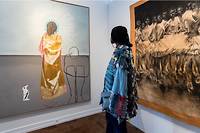 Une visiteuse devant des tableaux d'artistes venus exposés lors de la Foire 1-54 à Paris.

