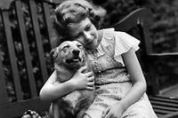 Elizabeth avec l'un de ses corgis, en 1936. Ses chiens ont été avant tout les compagnons d'une enfance solitaire.
