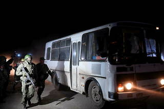 Des soldats russes surveillent les bus où ont été installés les combattants ukrainiens, le 16 mai.
