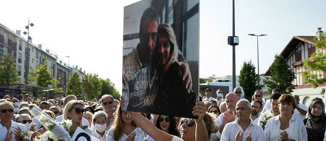 Veronique Monguillot, tenant une pancarte avec une photo d'elle et de son defunt mari Philippe Monguillot, lors d'une marche blanche le 8 juillet 2020.
