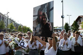 Véronique Monguillot, tenant une pancarte avec une photo d'elle et de son défunt mari Philippe Monguillot, lors d'une marche blanche le 8 juillet 2020.
