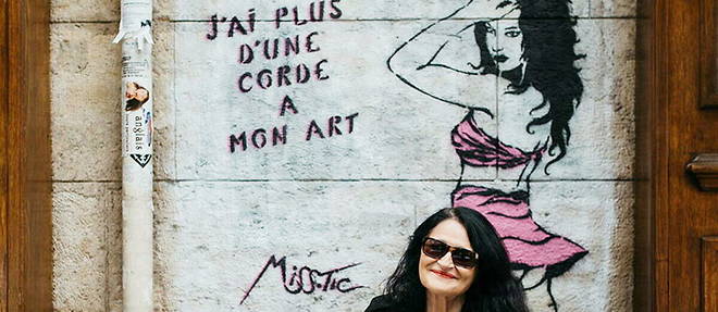 Miss. Tic devant la fresque qu'elle a dessinée sur la façade du café Le Balto, rue Mazarine à Paris.
