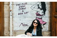 Miss. Tic devant la fresque qu'elle a dessinee sur la facade du cafe Le Balto, rue Mazarine a Paris.
