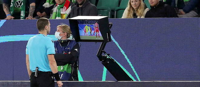 Georgi Kabakov, arbitre bulgare, consulte l'assistance video en bord de terrain lors du match entre le VfL Wolfsburg et le FC Seville le 29 septembre 2021.
